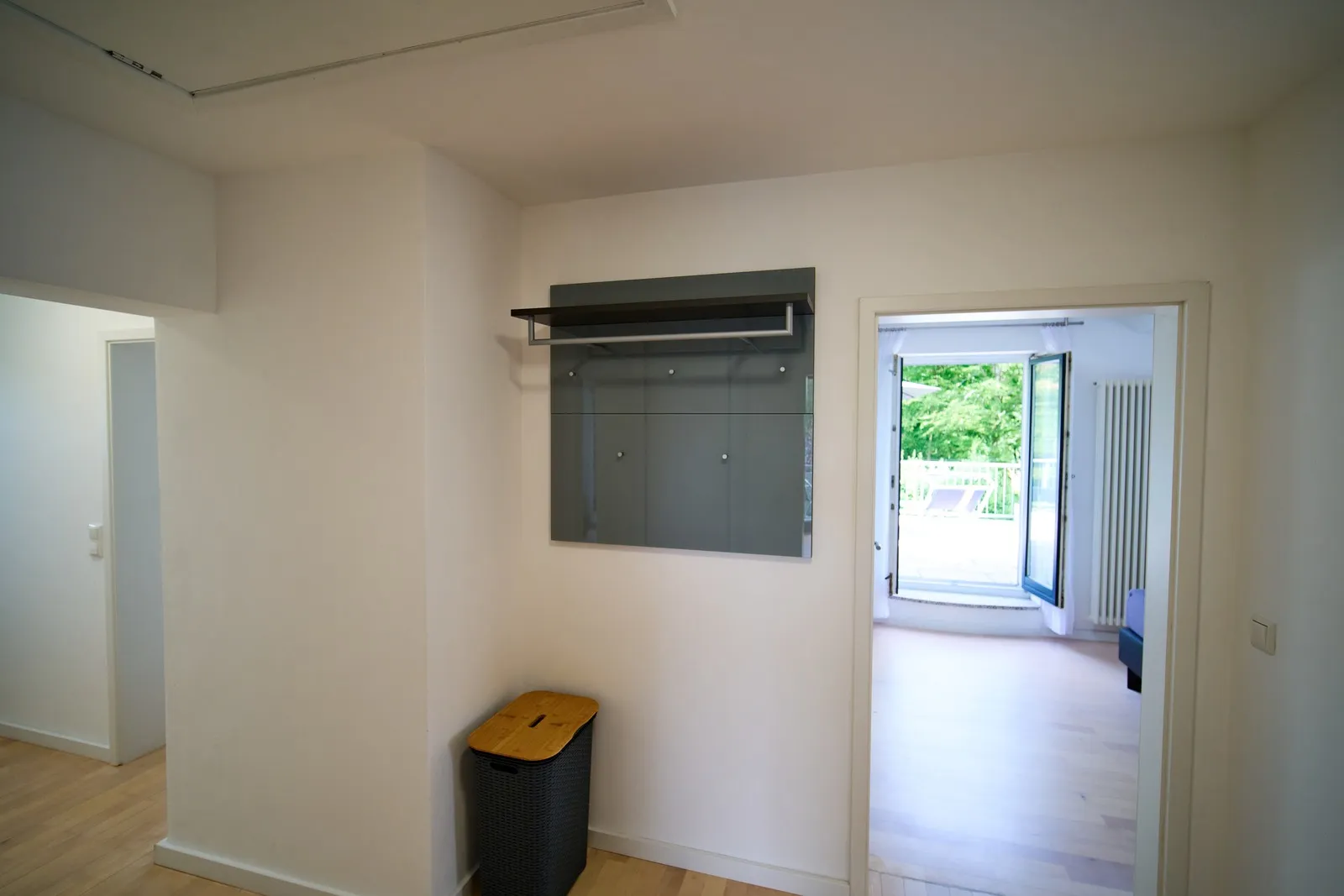Diele mit Garderobe, Wäschekorb und offener Tür zur Terrasse