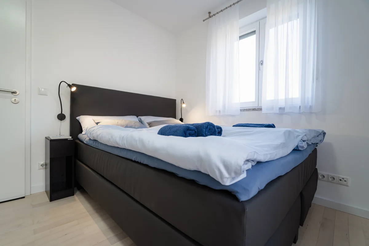 Bett in Schlafzimmer II mit frischen Handtüchern