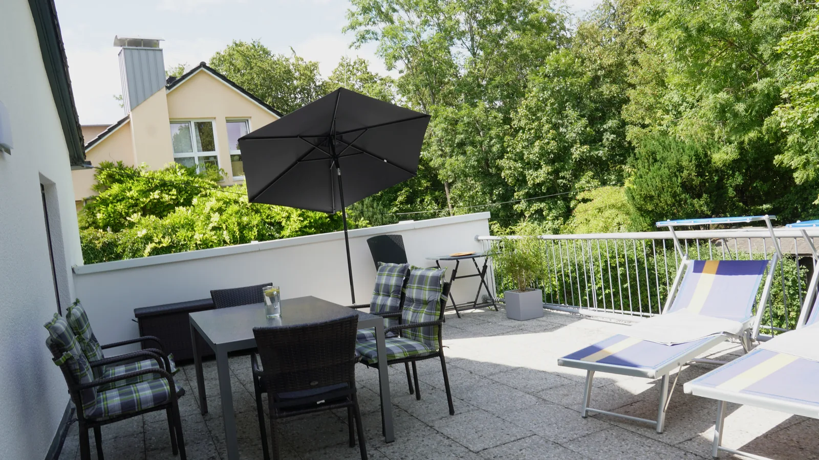 40 m² große Terrasse mit Esstisch und Sonnenliegen