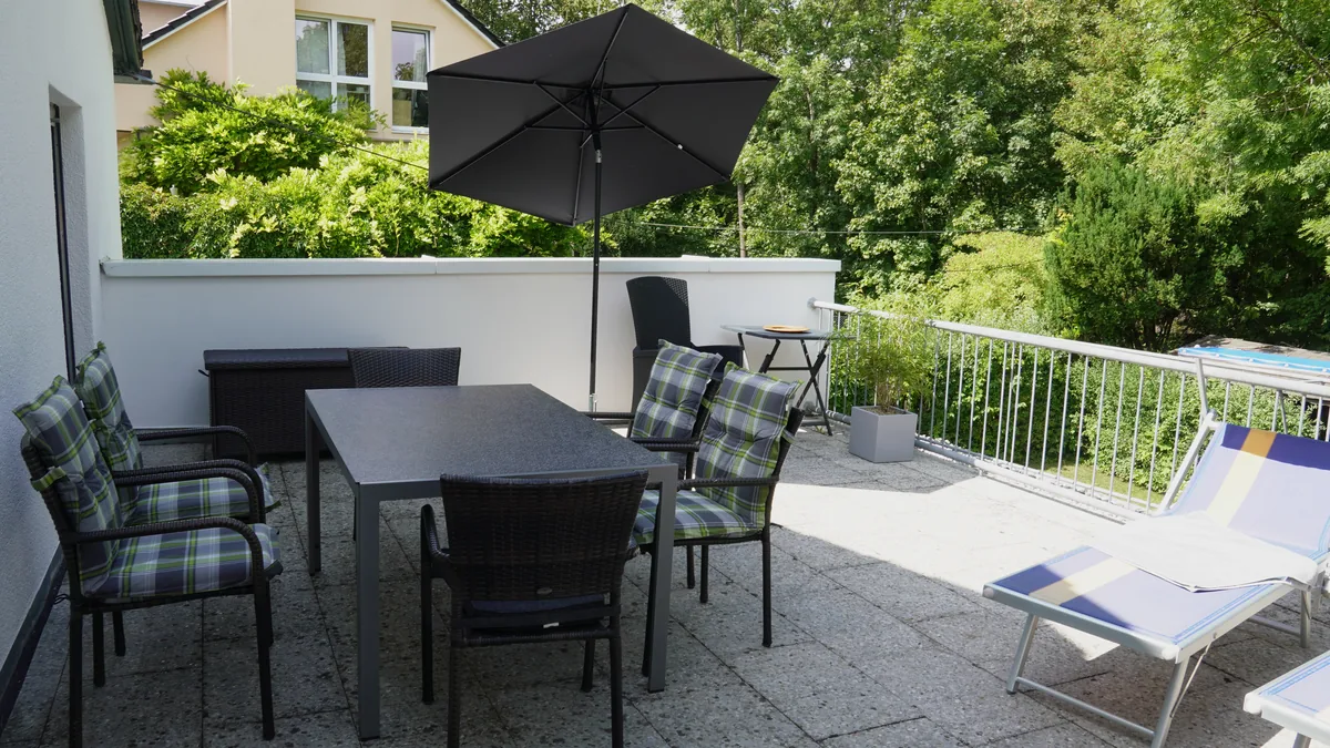 Outdoor-Esstisch und Sonnenliegen auf der Terrasse