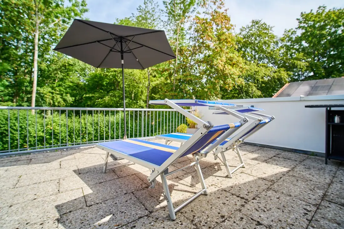 Zwei Sonnenliegen im Schatten des Sonnenschirms