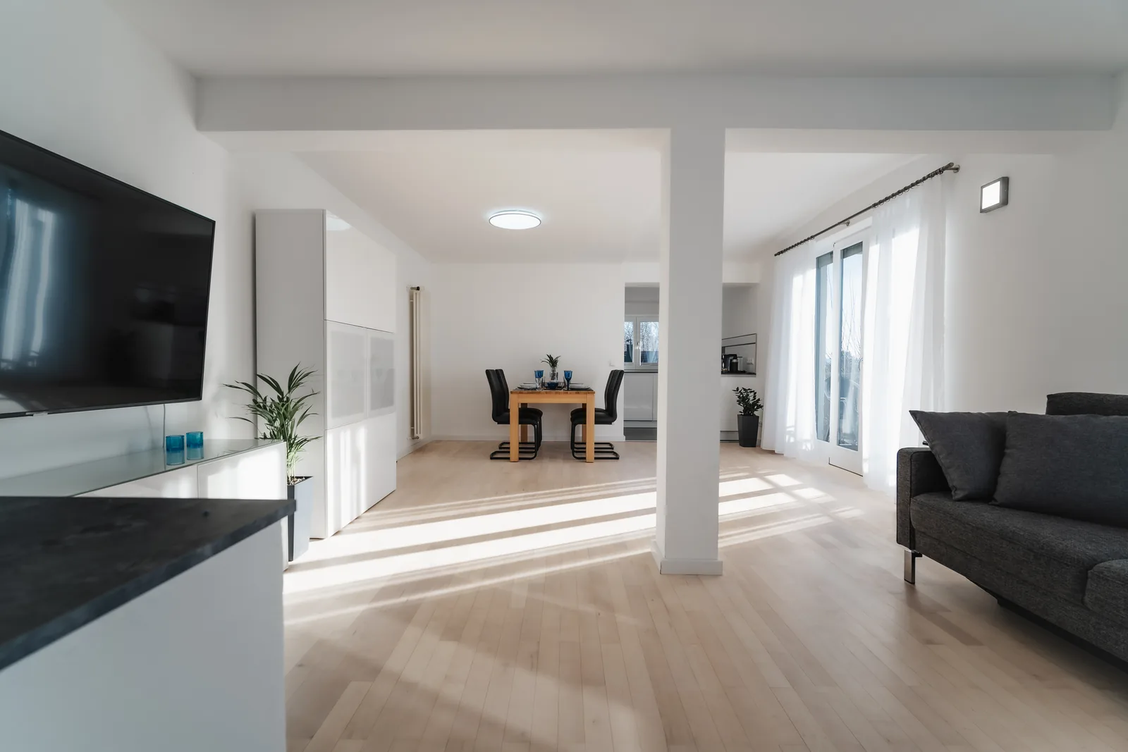 Wohnzimmer mit Smart-TV und Blick zum Essbereich