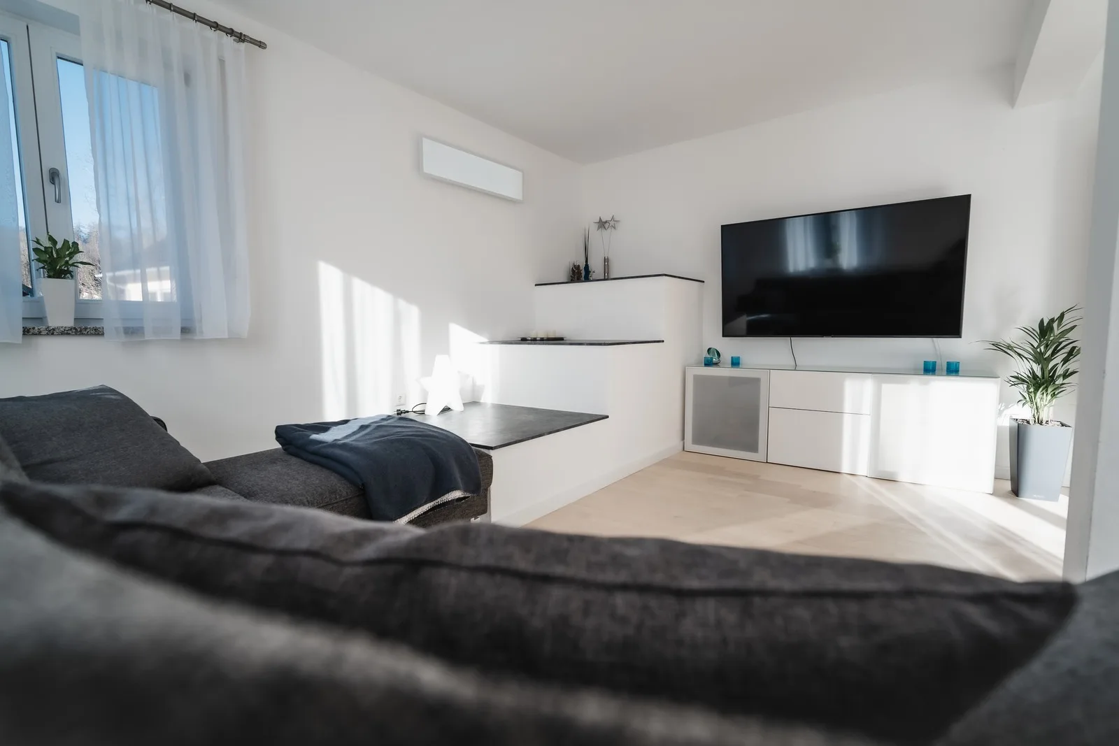 Großes Ecksofa vor dem Fernsehschrank