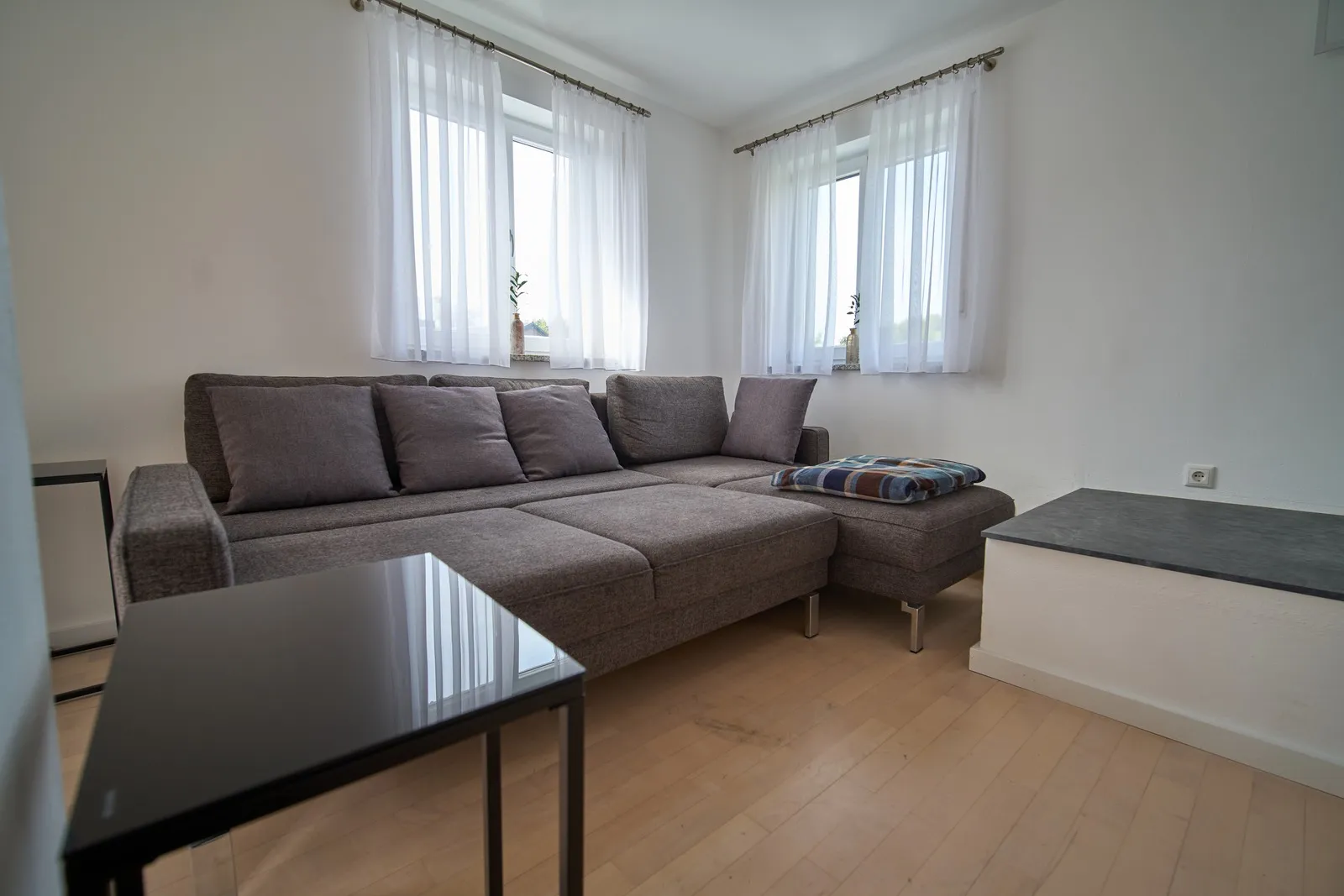 Ecksofa mit Couchtisch vor den Fenstern